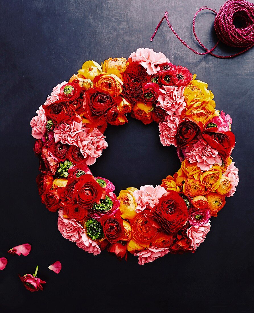 Wreath of multicoloured flowers on dark surface