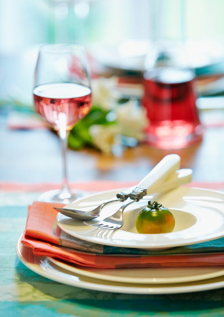 Tischgedeck dekoriert mit grüner Tomate