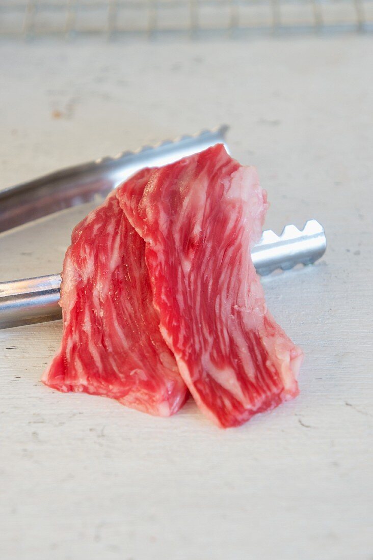 Wagyu and a pair of metal tongs