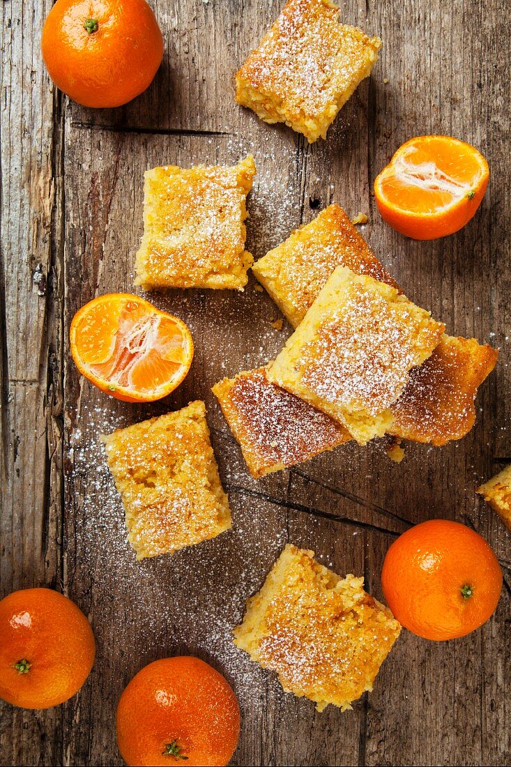 Mandarin cake slices and fresh mandarins (seen from above)