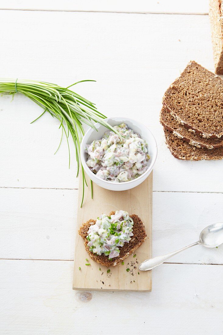 A slice of bread topped with soused herring tartar and chives