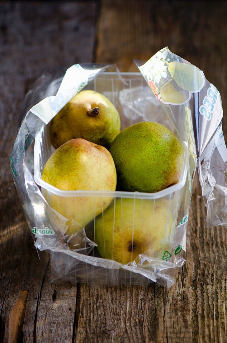 Pears in a plastic box wooden surface