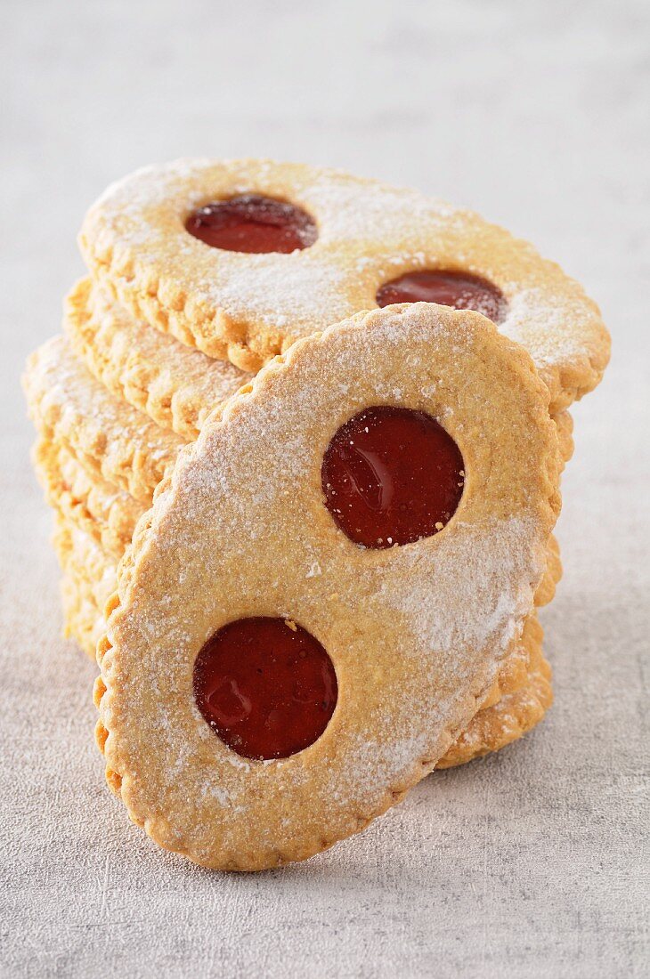 A stack of jam biscuits with icing sugar