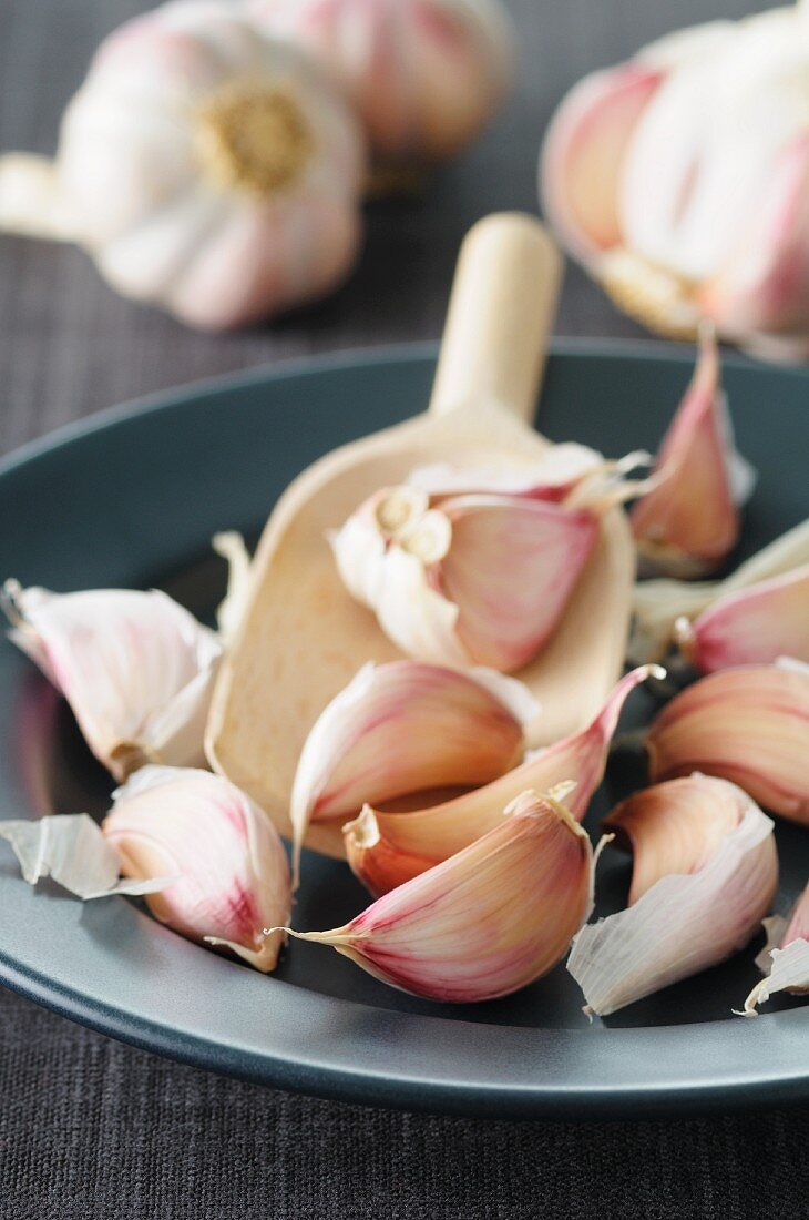 Garlic on a wooden scoop on a plate