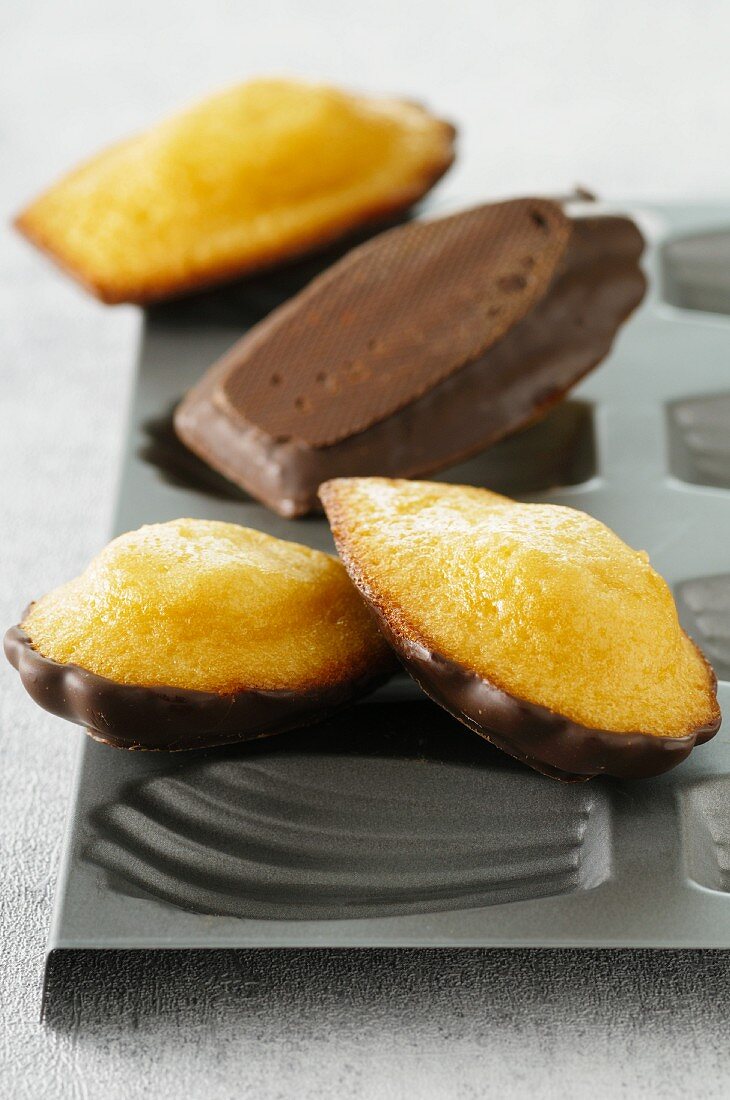 Madeleines with chocolate glaze on top of the baking tin