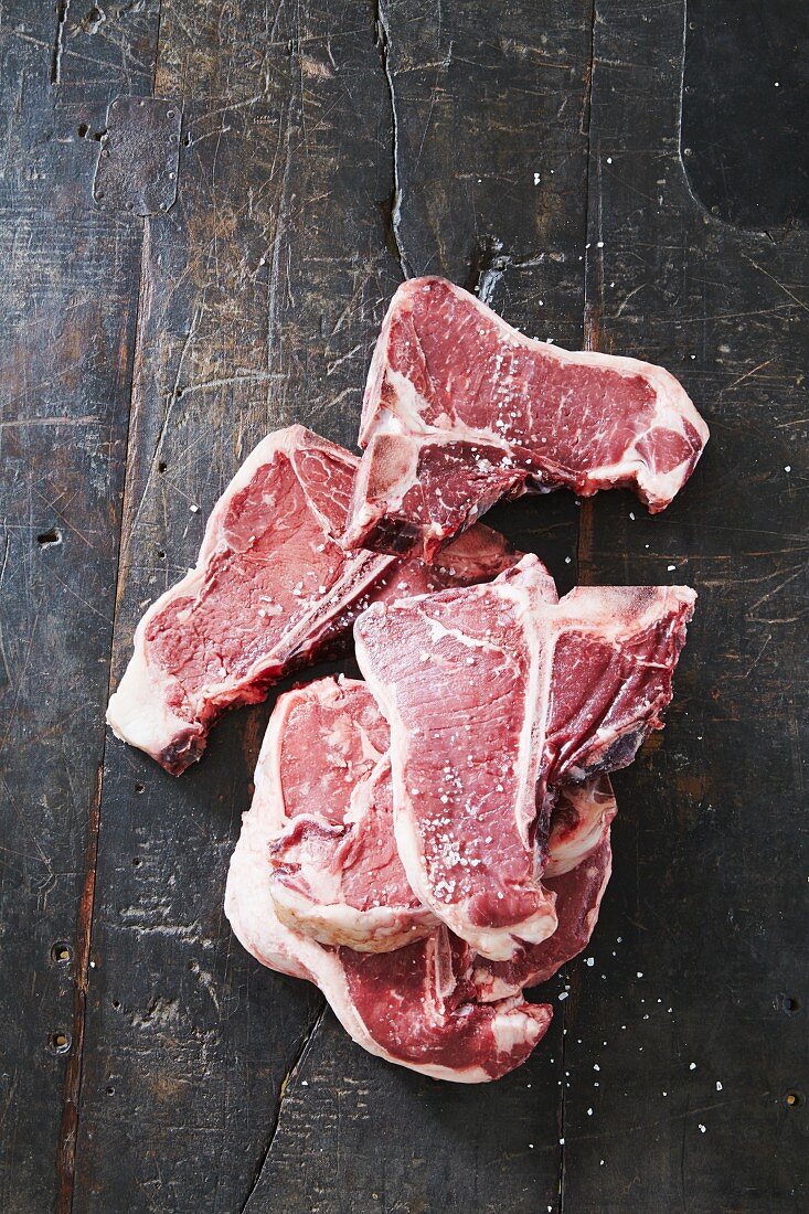 Raw T-bone steaks with salt
