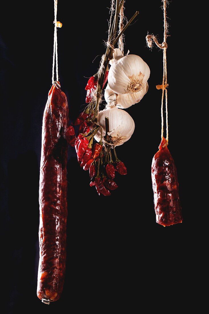 Hanging smoked sausages, garlic and chilli peppers