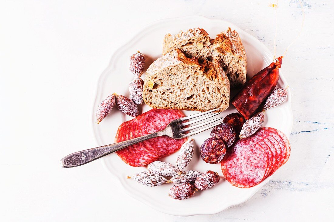 Verschiedene Salami- & Wurstsorten mit Brot auf Teller