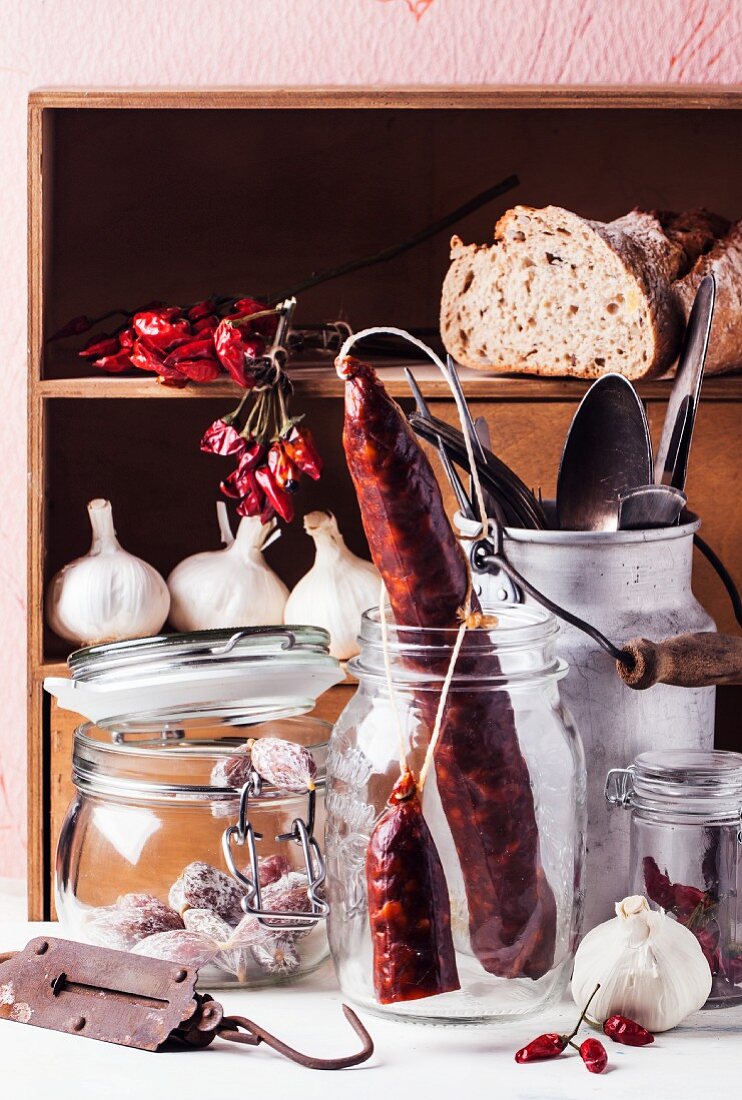 An arrangement of various smoked sausages in storage jars