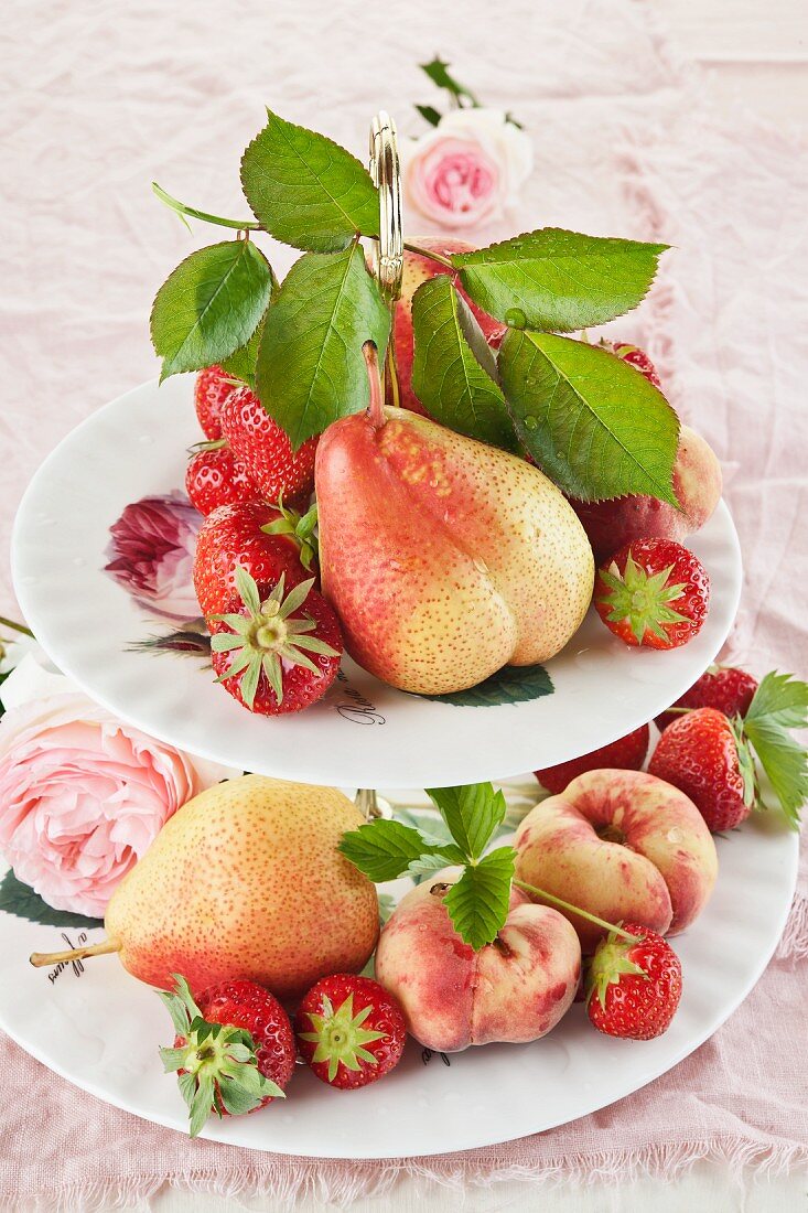 Fruits, berries and roses on a cake stand