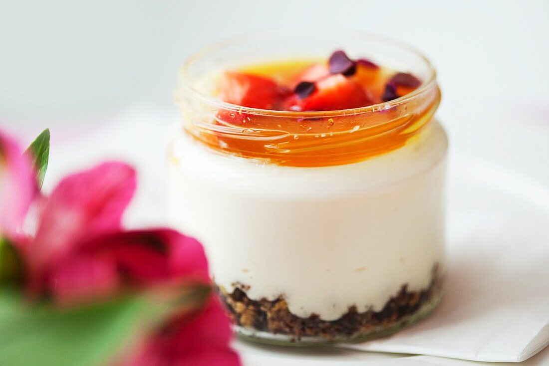 White chocolate cream with caramel and strawberries in a screw top jar