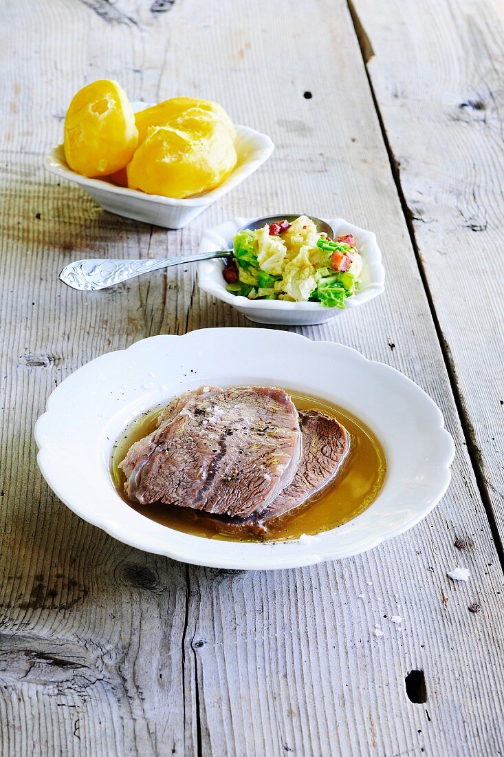 Boiled beef in stock with potatoes and a small salad