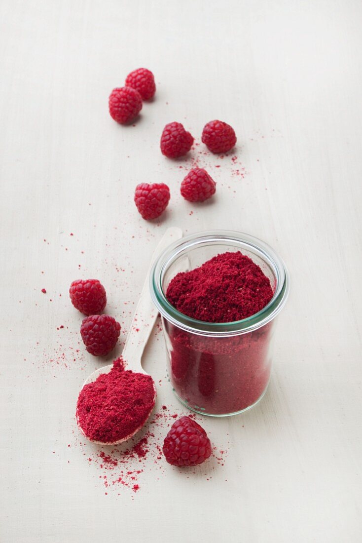 Raspberry fruit powder in a glass and on a spoon