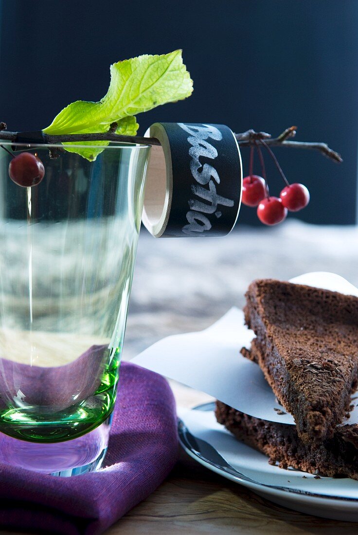 Zwei Schokokuchen und Trinkglas mit beschriftetem Serviettenring an einem Kirschzweig