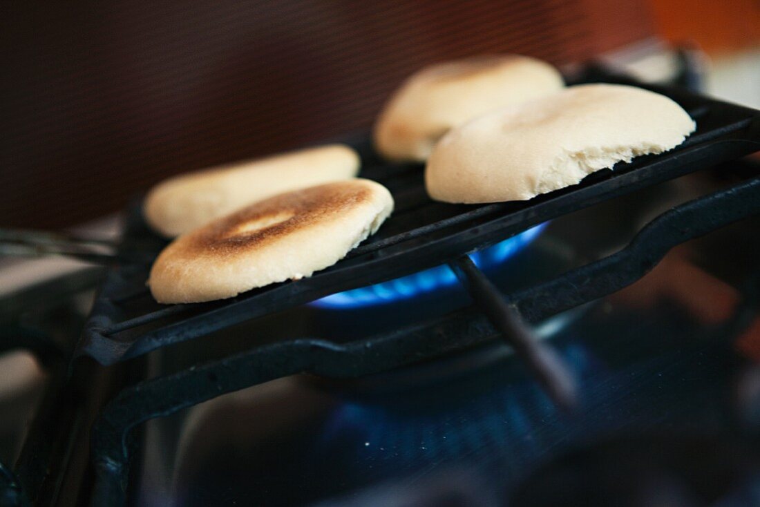 Halved bread rolls on a grill