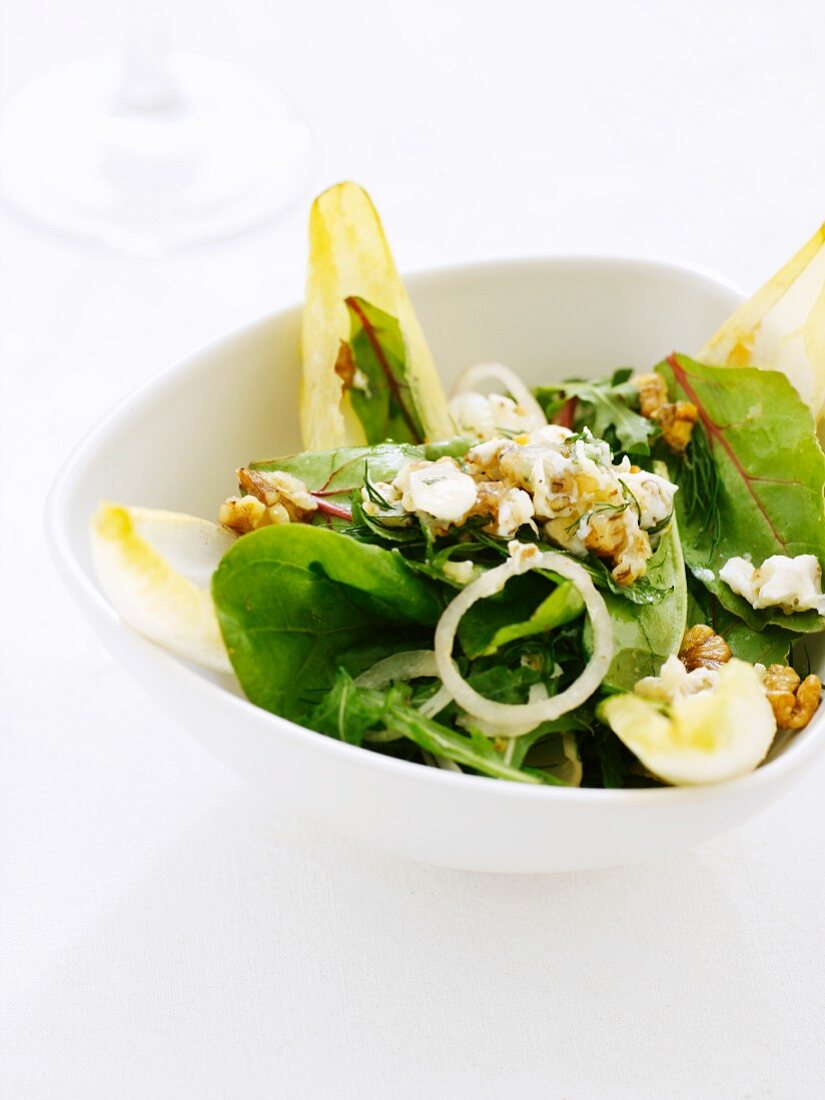 A mixed leaf salad with walnuts and onions