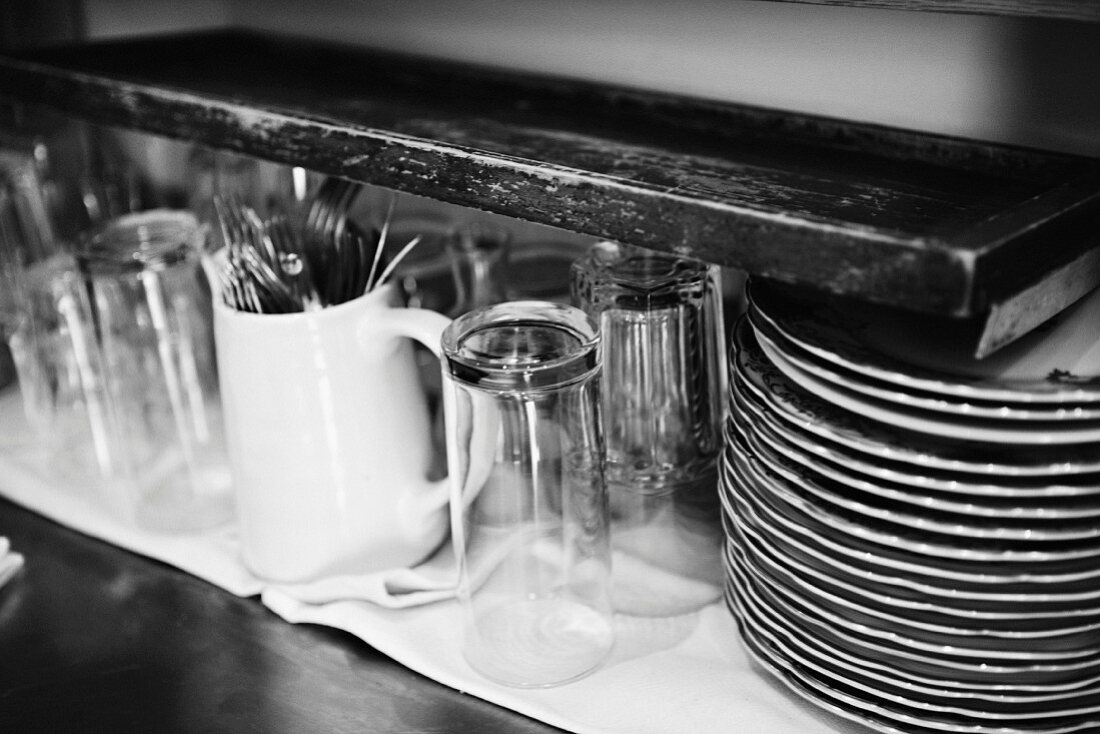 Glasses, cutlery and a stack of plates