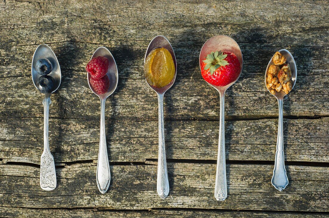 Frische Früchte & Nüsse auf Löffeln als Müslizutaten