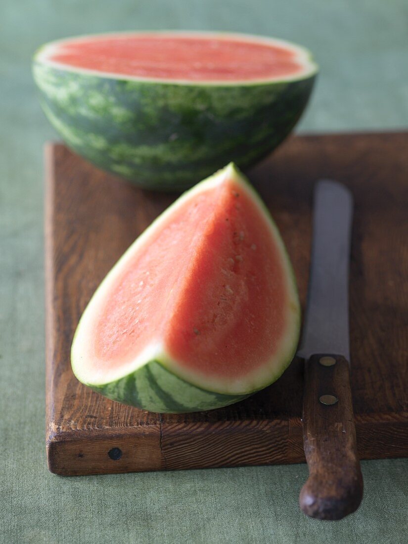 Mini-Wassermelone mit Messer auf Holzbrett
