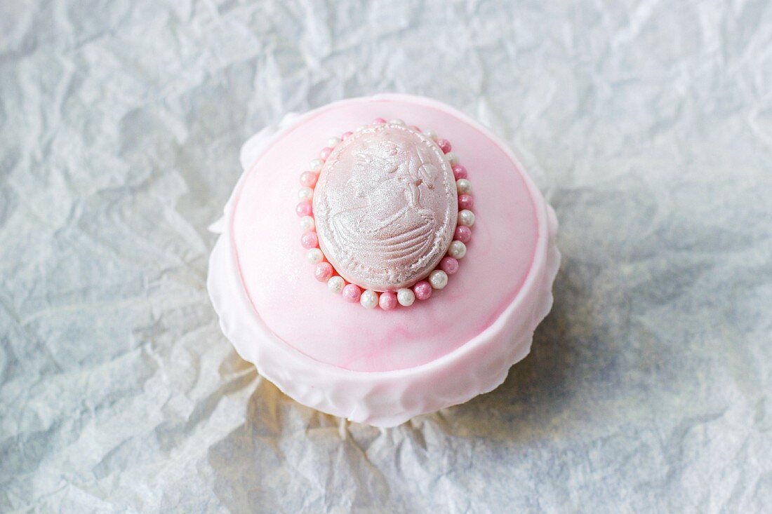 A cupcake decorated with an old-fashioned medallion