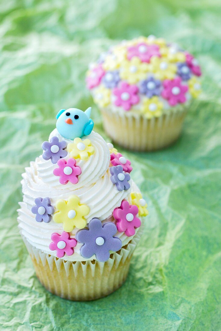 Lemon cupcakes decorated with sugar flowers and a bird