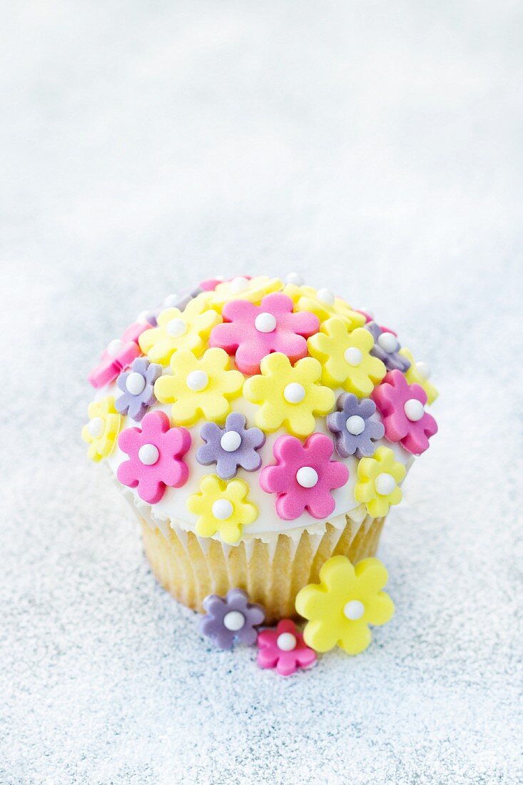 Ein Cupcake mit Zuckerblüten dekoriert