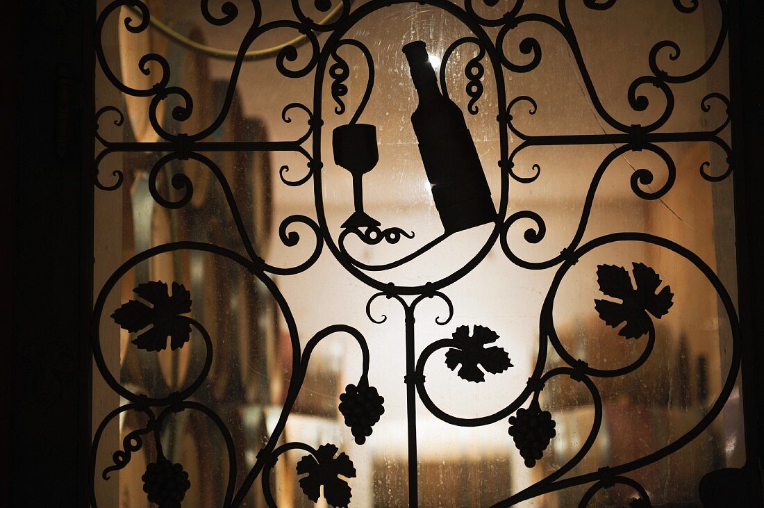 A wrought iron gate leading to a wine cellar