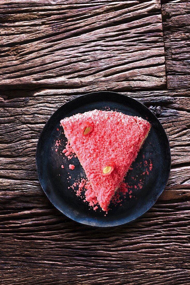 Slice of cake decorated with pink almonds (France)