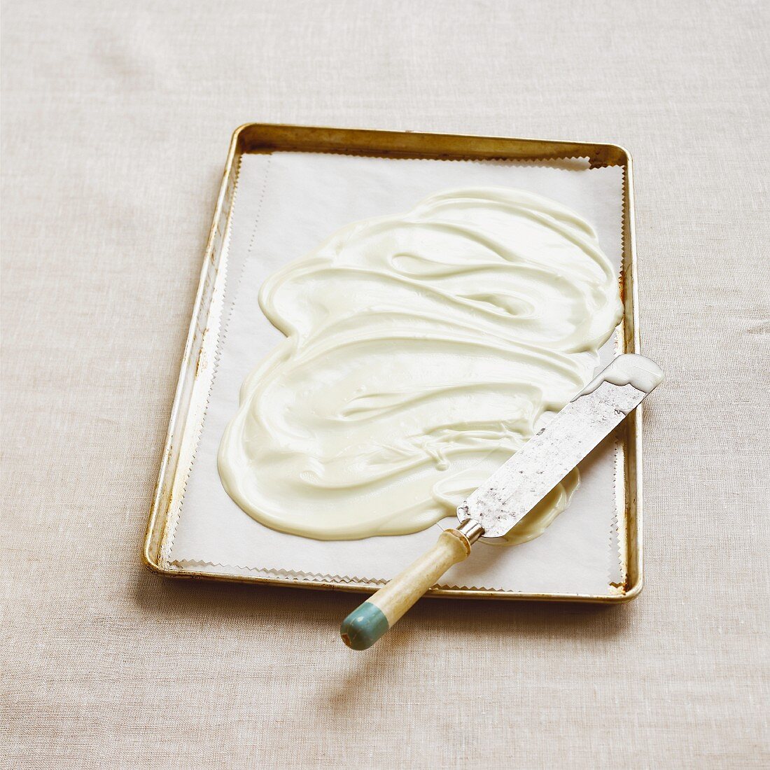 White chocolate cooking chocolate on a baking tray with a knife