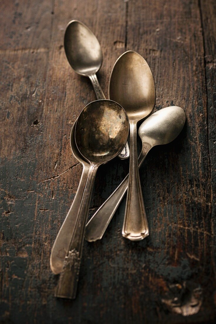 Old silver spoons on a wooden table
