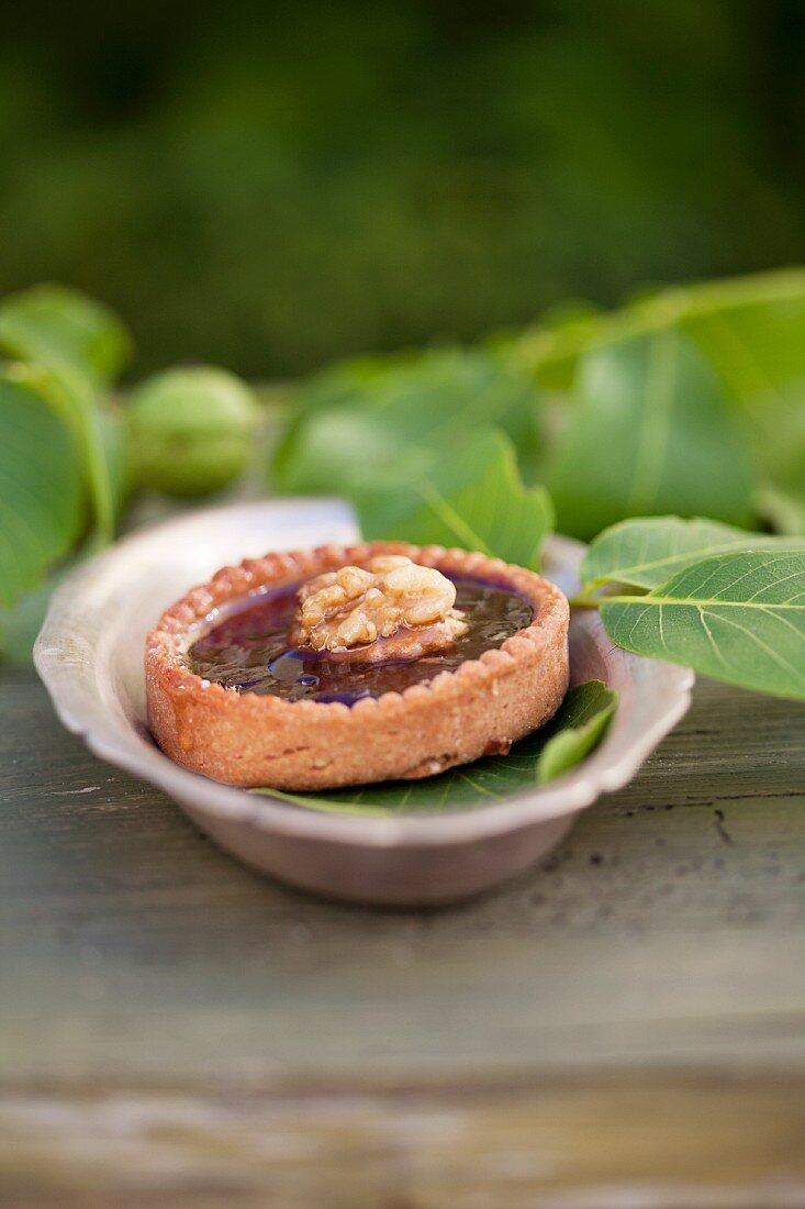 Linzertörtchen (nut and jam tartlet) decorated with a walnut