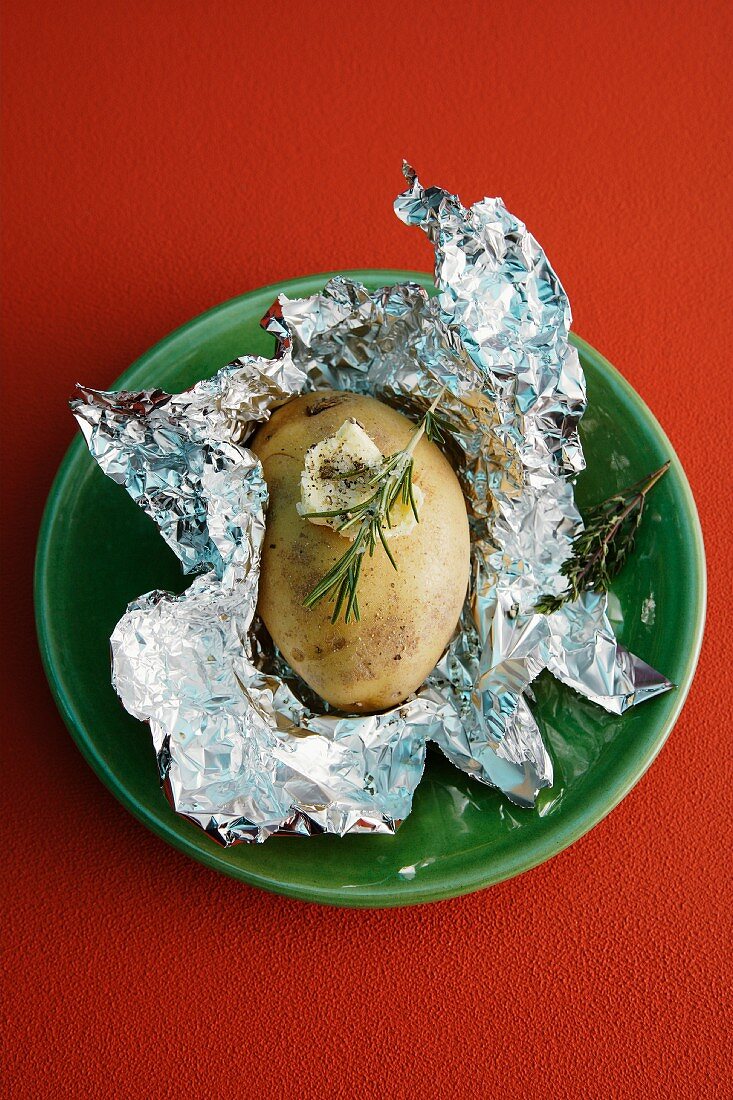 A baked potato with rosemary
