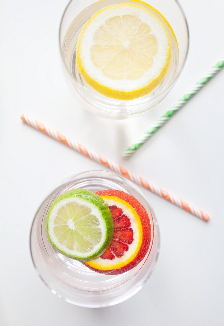 Citrus fruit slices in two glasses of water