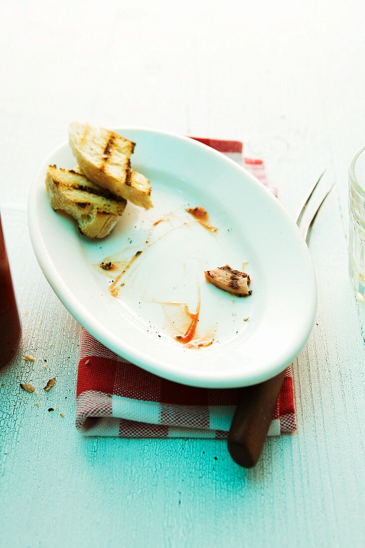 The remains of sausage and bread plate