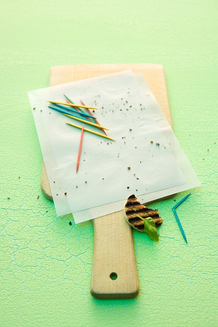 Breadcrumbs and toothpicks on a piece of paper