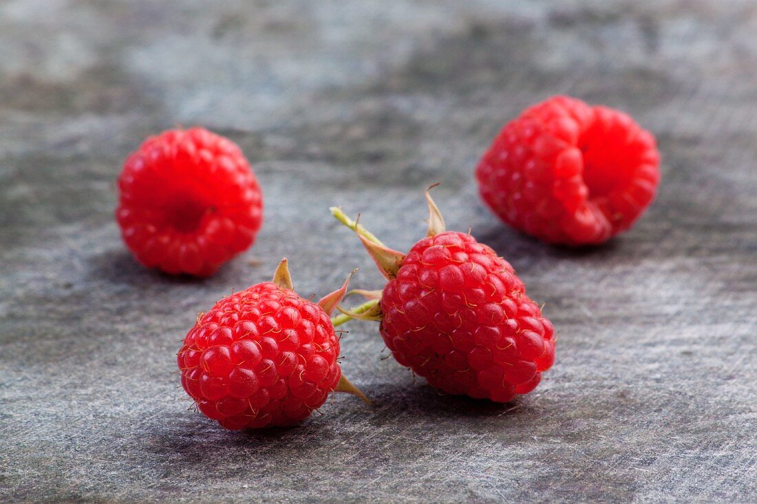 Vier Himbeeren auf Holzuntergrund