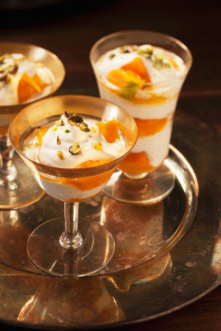 Mango trifle with pistachios in stemmed glasses