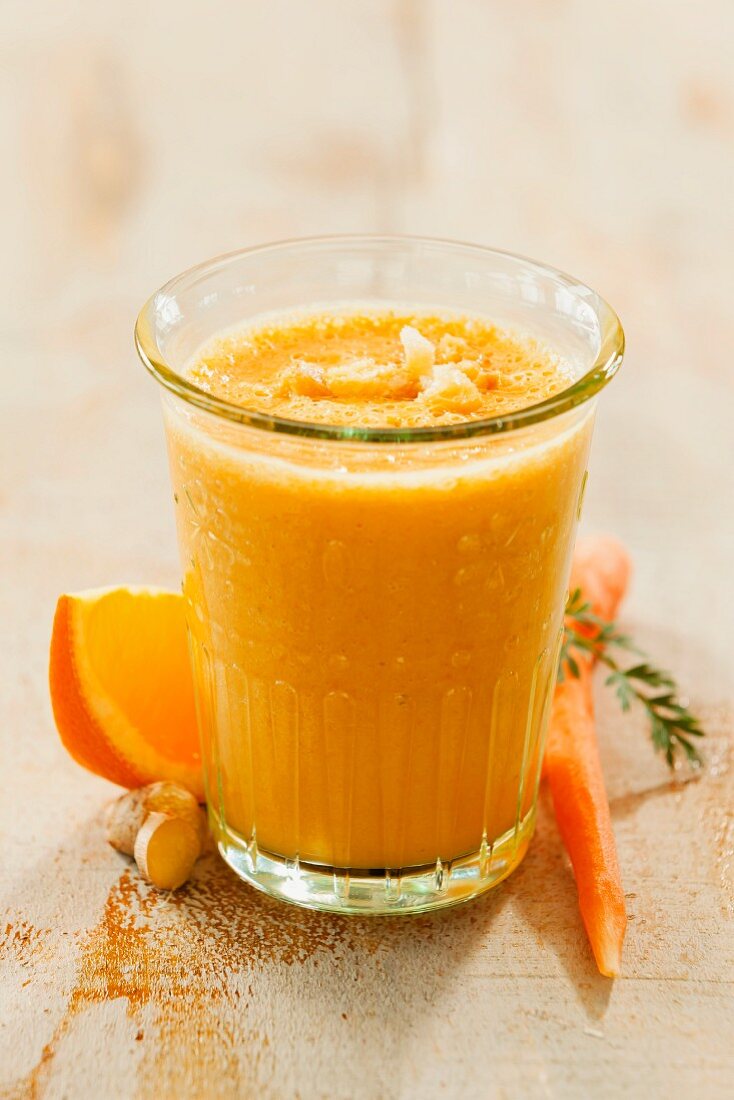 A carrot and orange smoothie in a glass