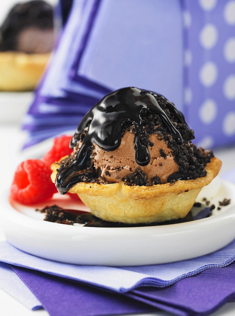 A tartlet filled with chocolate ice cream topped with chocolate sauce