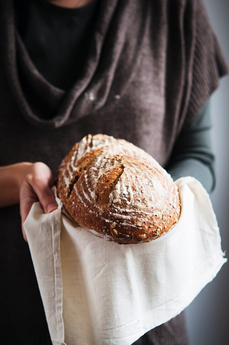 Frau hält Brot auf Tuch