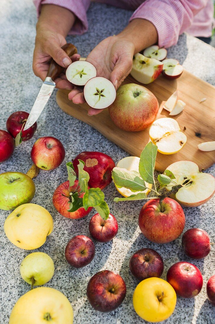 Various types of apples, whole and halved
