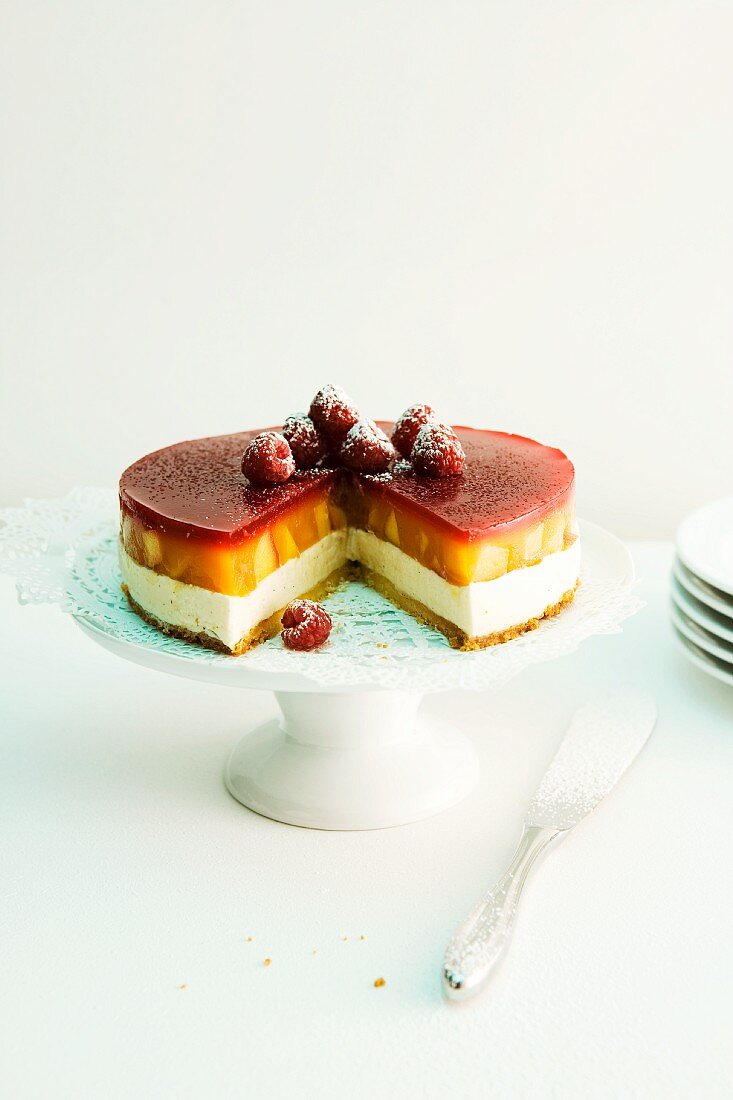 Peach Melba cake with raspberry jelly on a cake stand