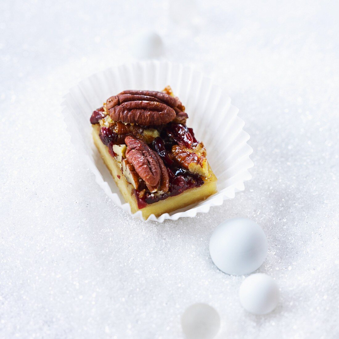 Ein Stück Pekan-Cranberry-Kuchen in Papiermanschette