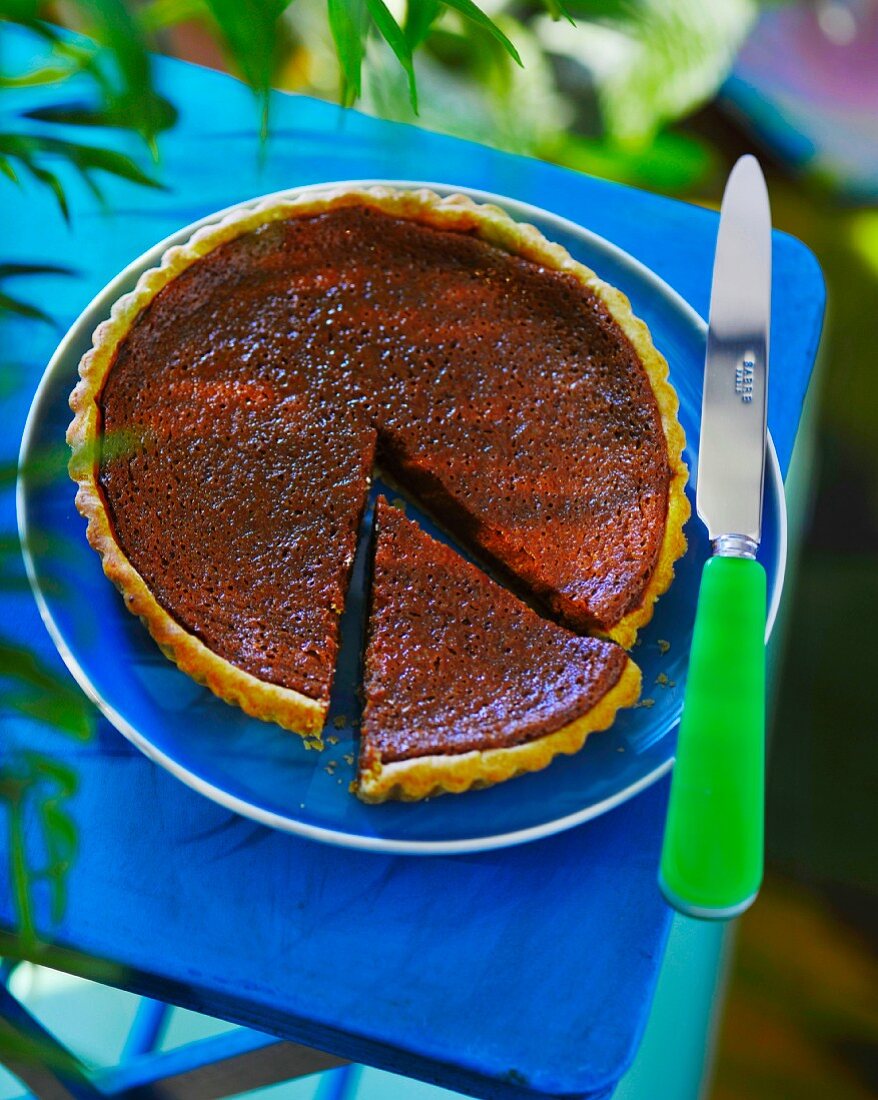 A caramel tart with a slice cut out