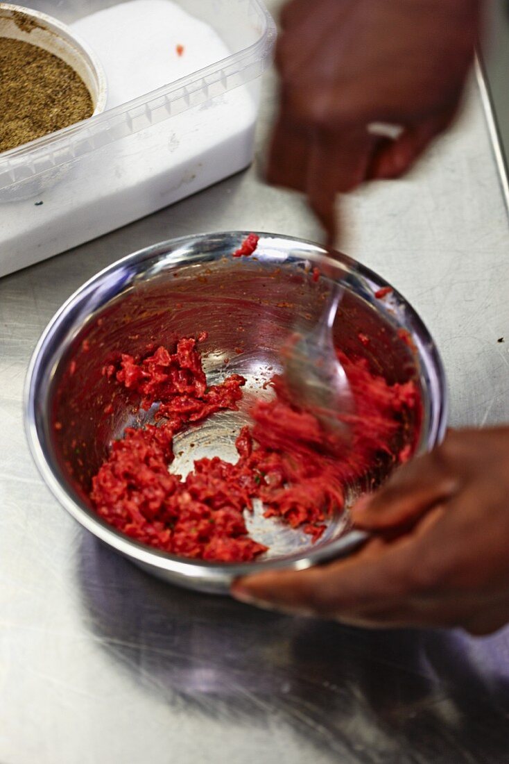 Hackfleisch mit Gewürzen vermischen