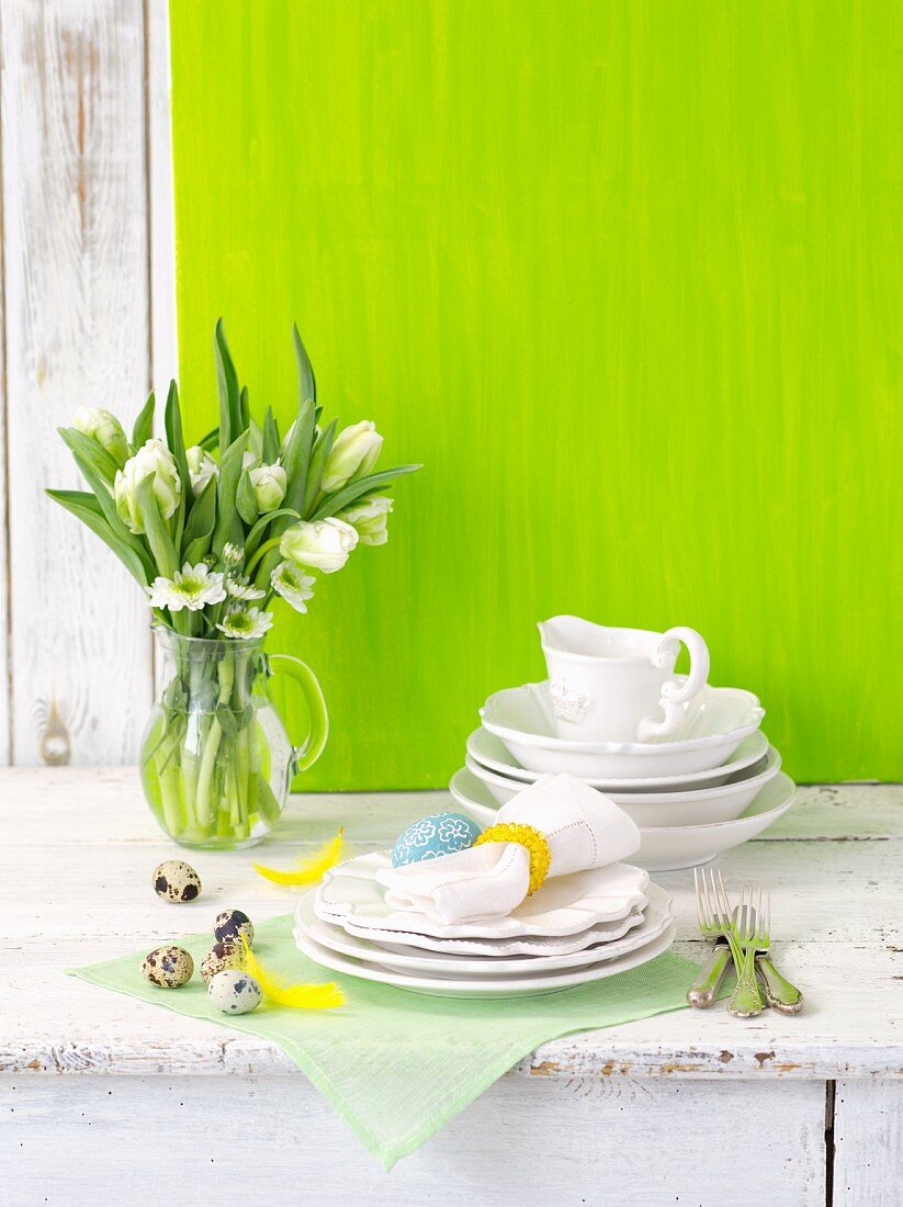 White crockery with Easter decorations and a bunch of spring flowers