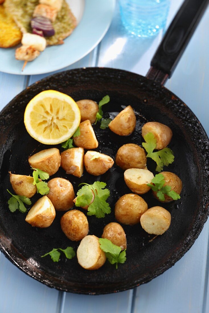 Fried potatoes with coriander in a pan