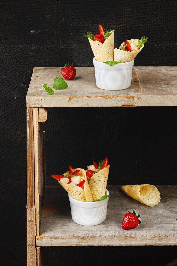 Wafer cones filled with strawberries and mint