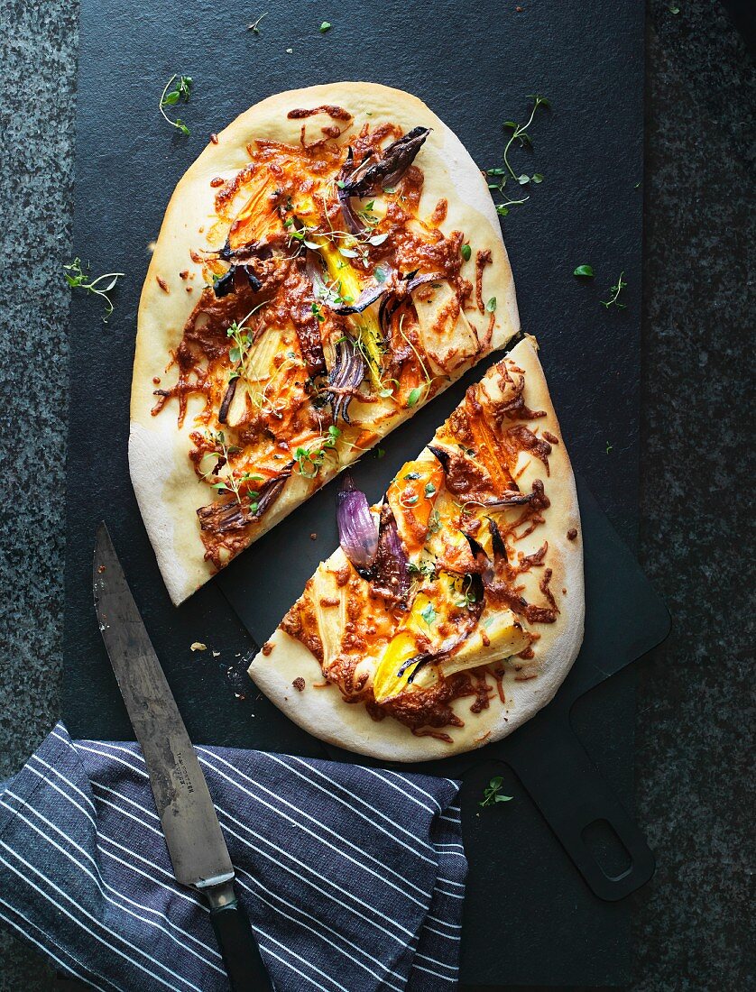 Pizza mit roten Zwiebeln, bunten Möhren und gelber Paprika