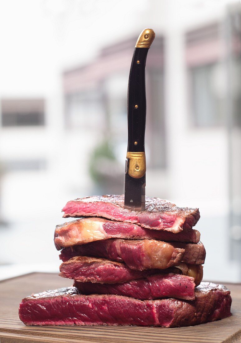 Stack of entrecote steaks with a steak knife